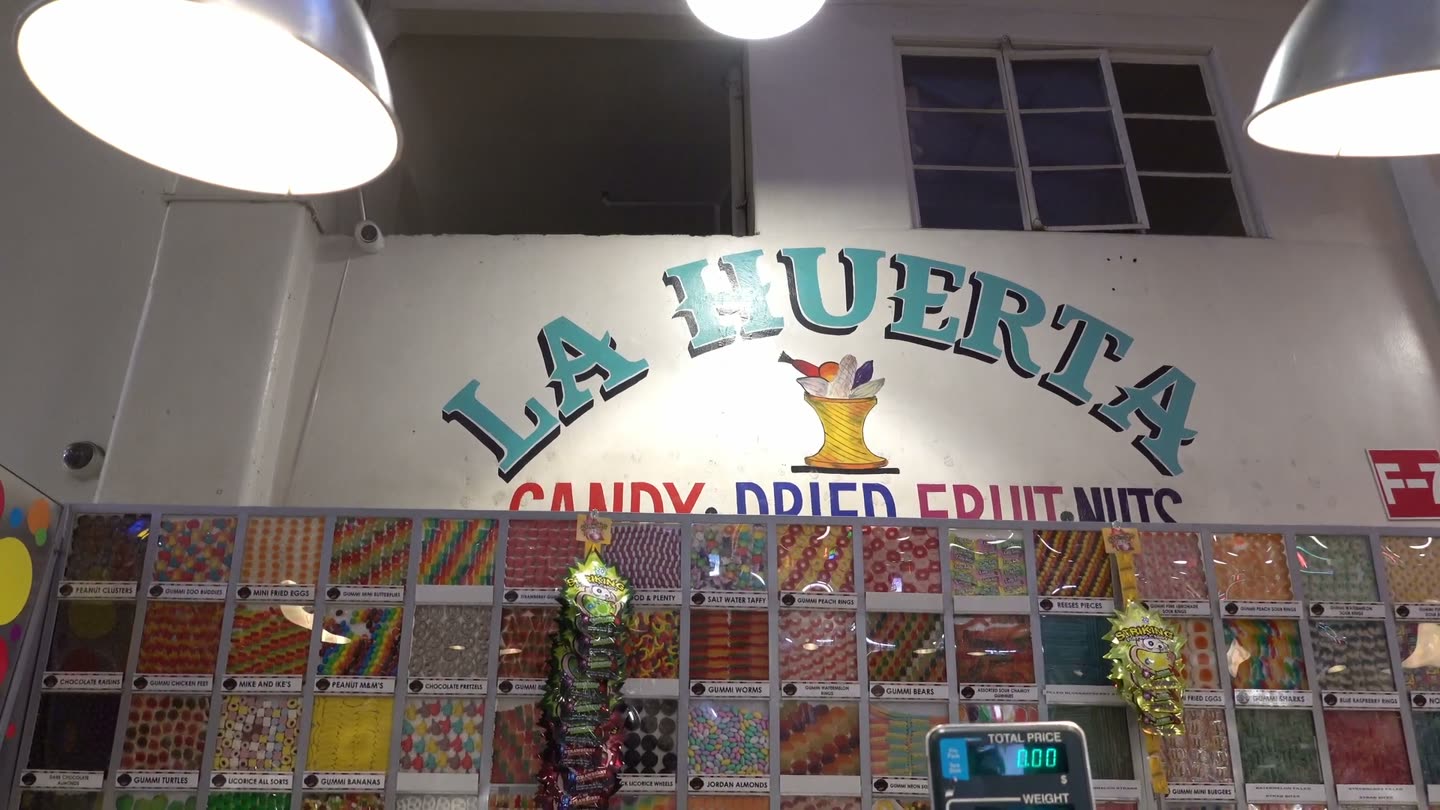 La Huerta Candy stall with a wall of colorful bins of candy, dried fruit, and nuts