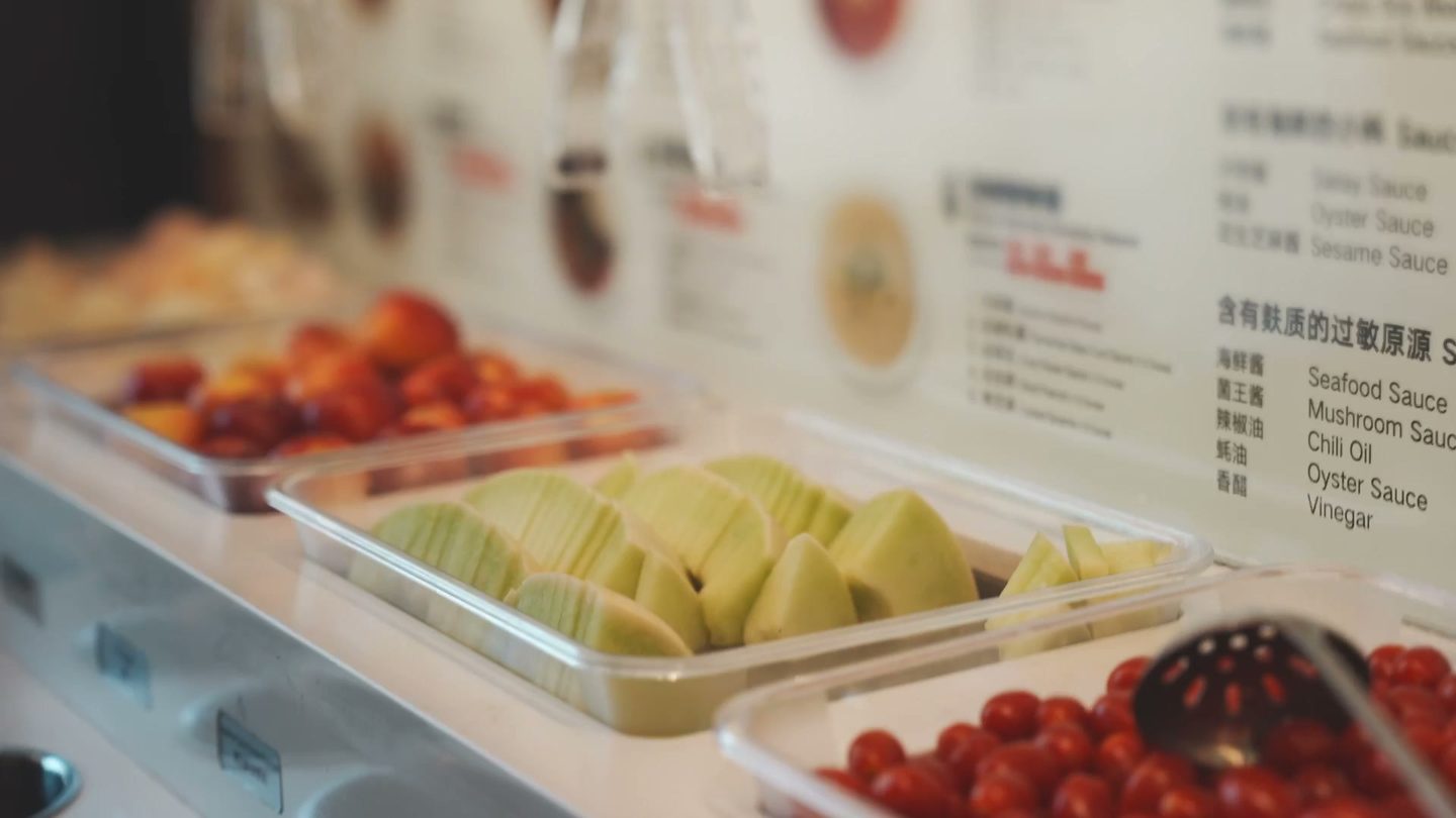 Fresh fruit, cut melon, and cherry tomatoes at the Haidilao sauce bar