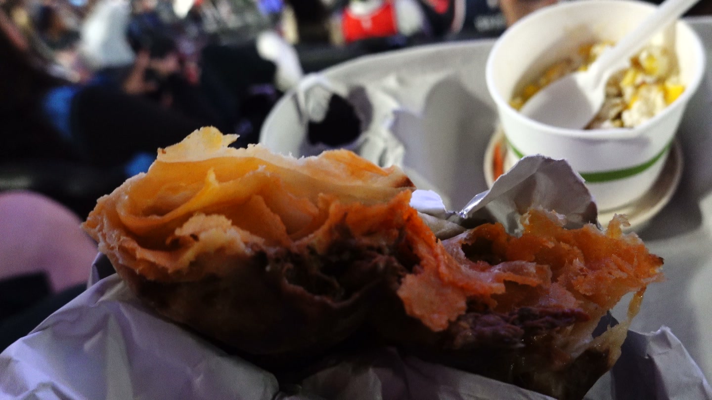 Cross-section of the birria stack showing the beef and tortilla layers at Intuit Dome
