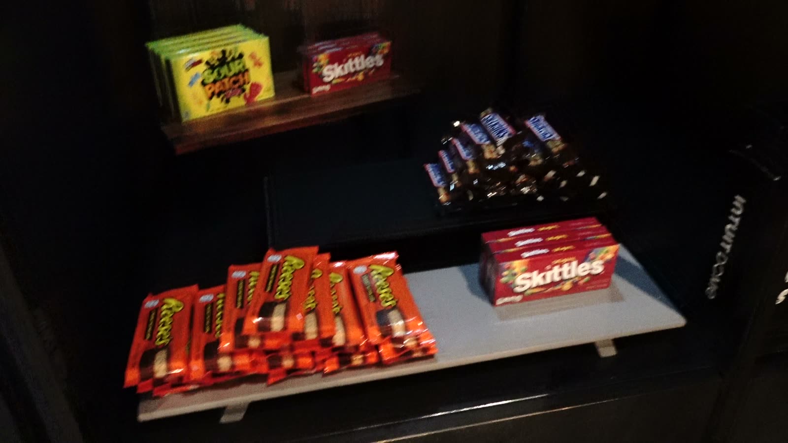 Full-size candy bars and boxes on display in the floor lounge at Intuit Dome