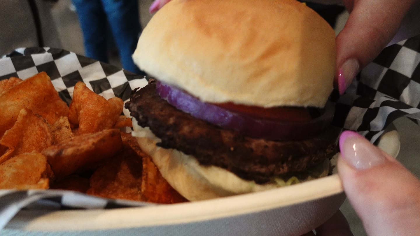 The burger and chips we tried at BMO Stadium in April 2026; Lisa ordered hers without cheese.