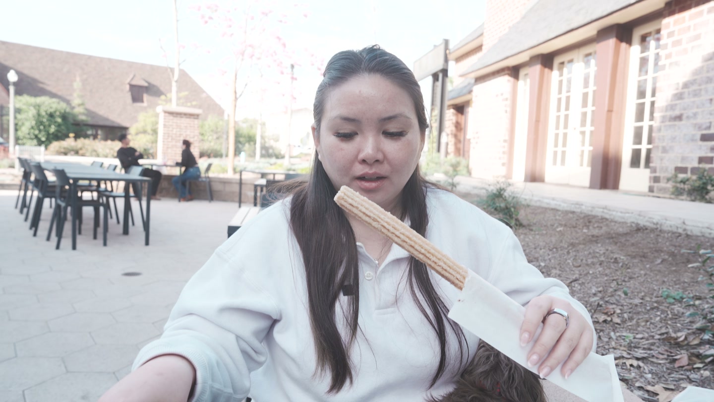 Lisa holding the XL churro from Las Chelaguas on Rodeo72’s patio.