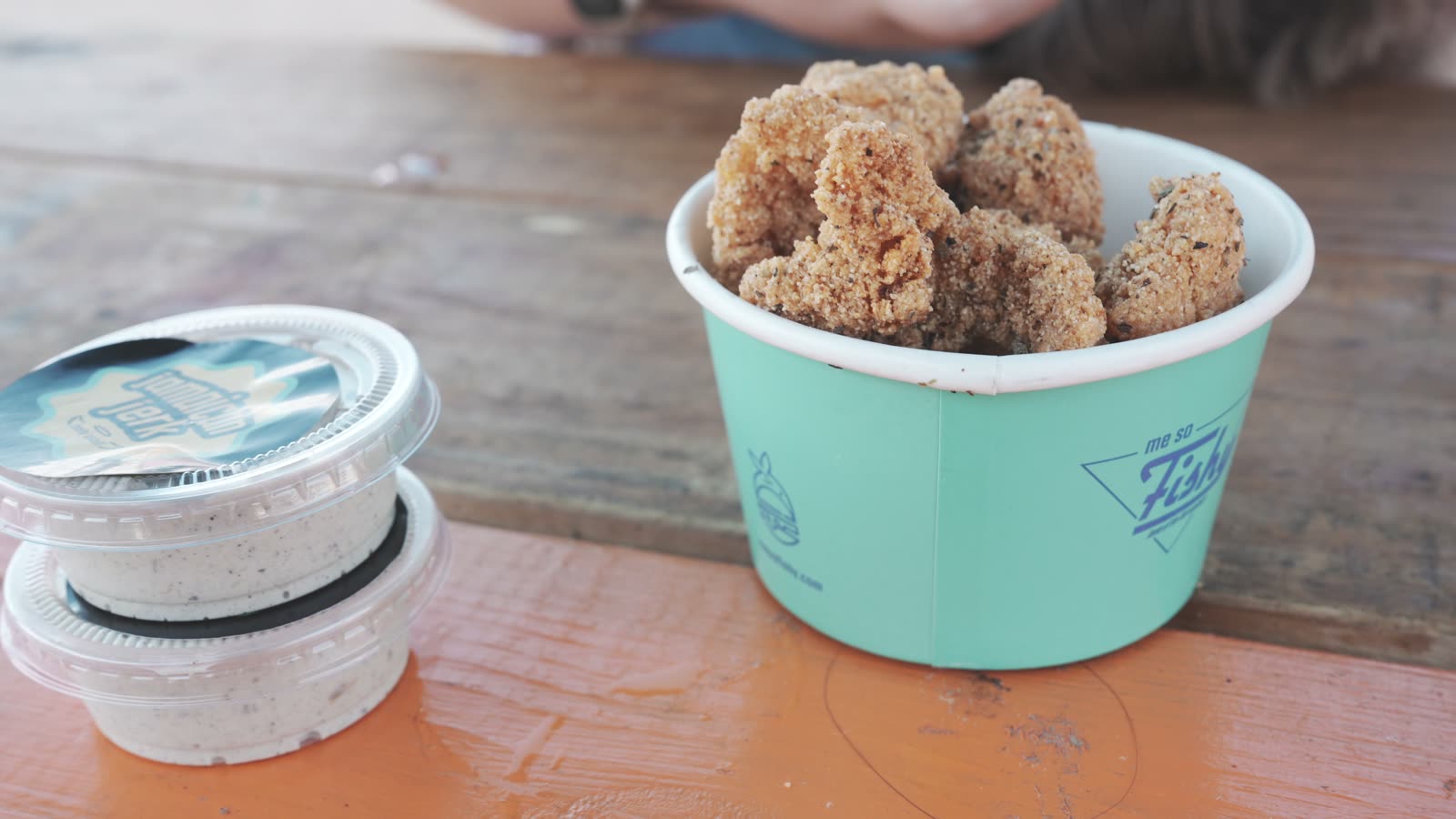 Me So Fishy catfish bites in a cup with a side of sauce