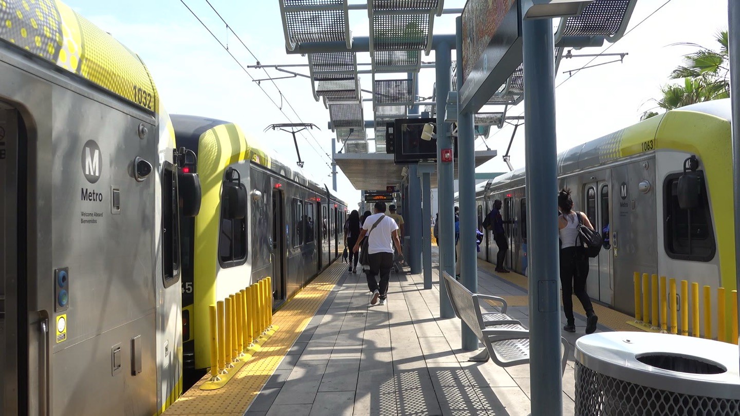 An E Line light rail train with its yellow front at an outdoor platform