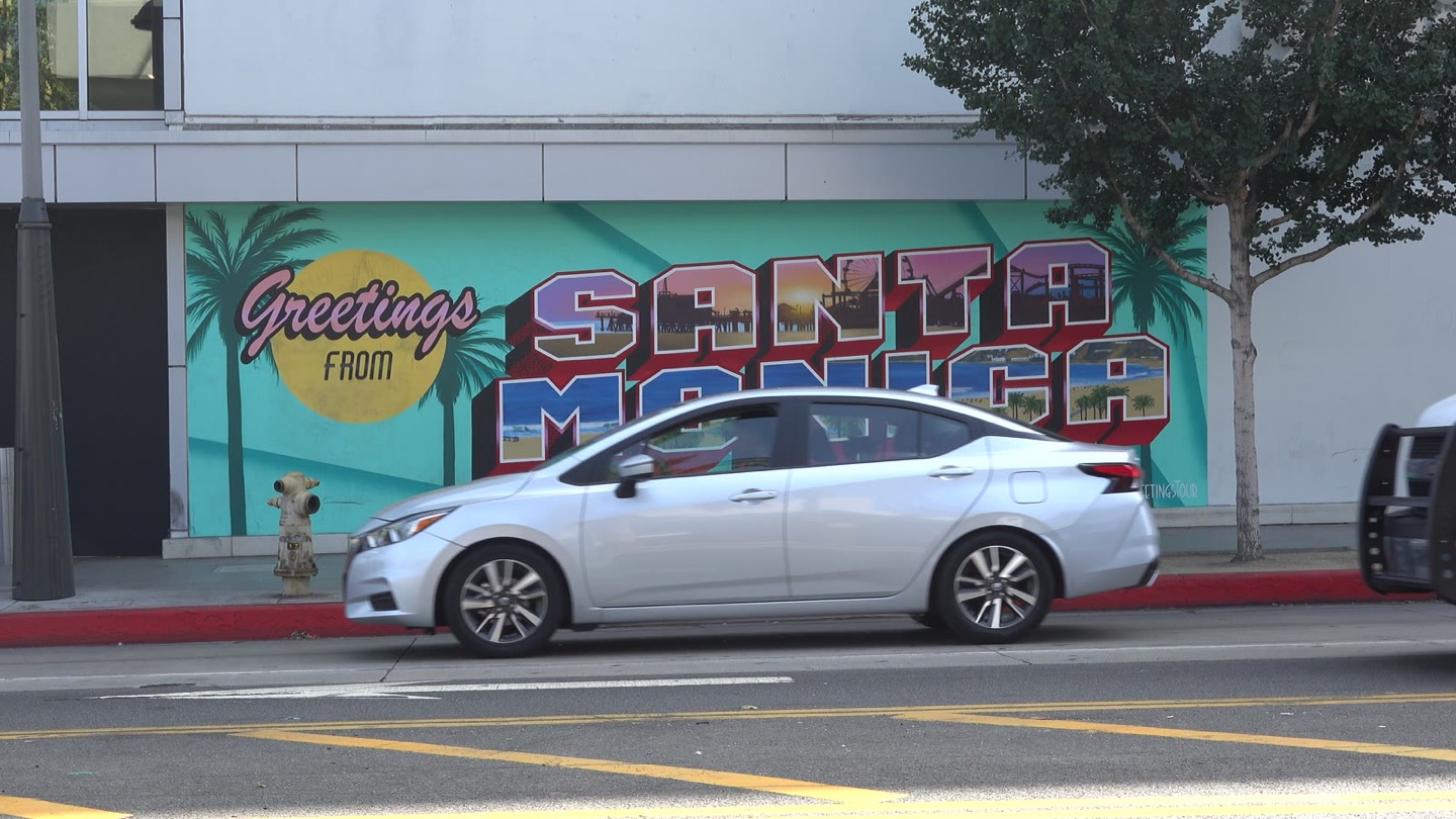 A Greetings from Santa Monica postcard-style mural on a wall along Colorado Avenue
