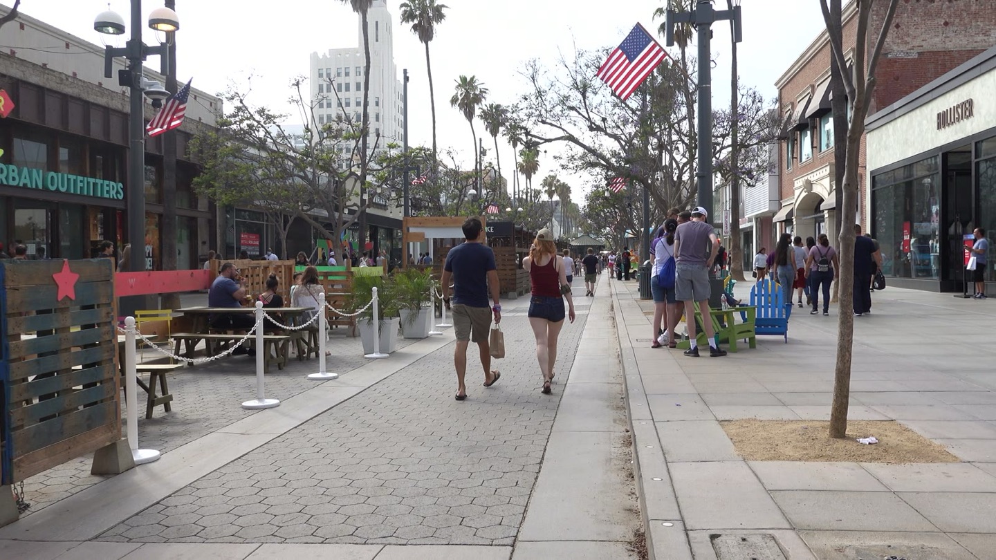 People walking down the Third Street Promenade in Santa Monica on a sunny afternoon