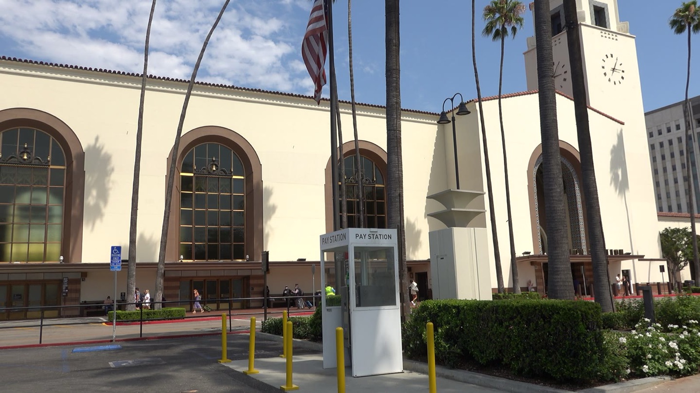 The front of Los Angeles Union Station on Alameda Street, with its clock tower and rows of palm trees
