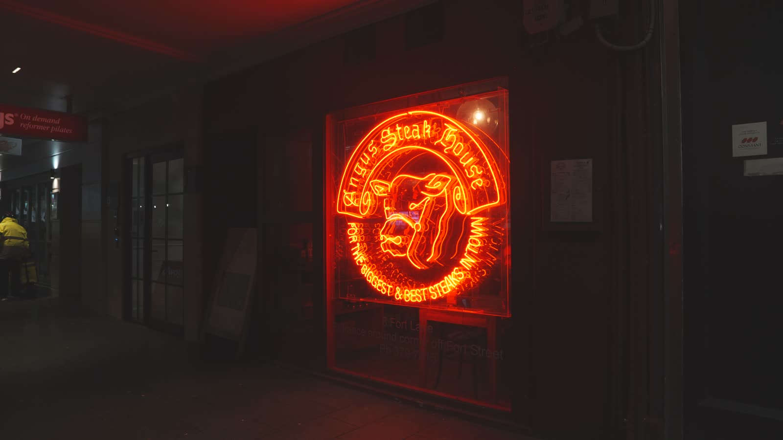 The glowing red neon sign at Angus Steak House in Auckland
