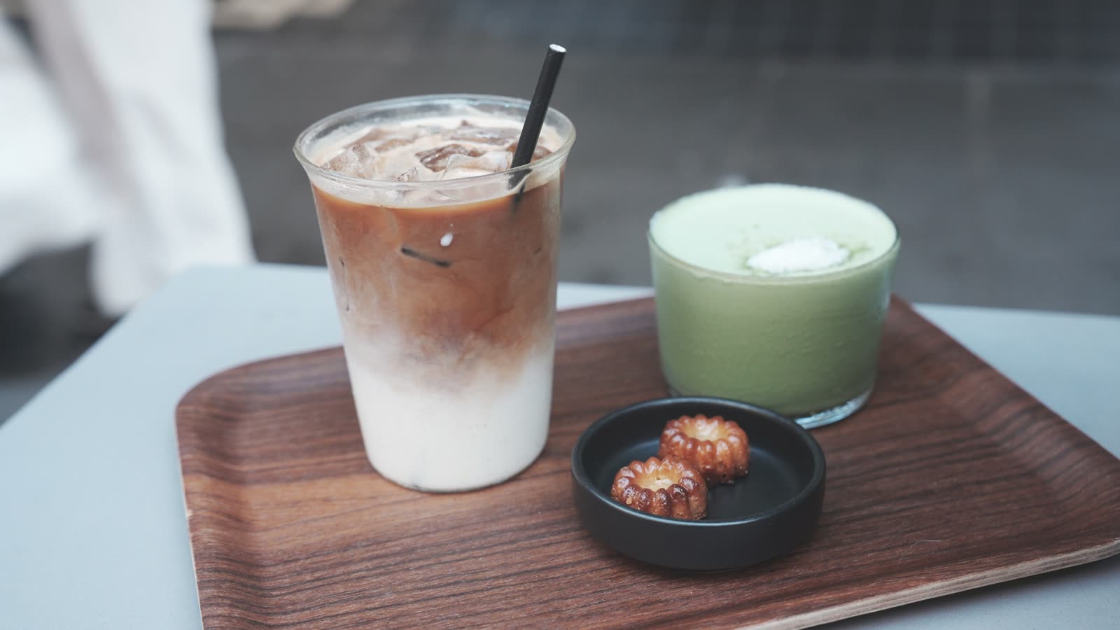 Iced flat white, honey miso matcha, and mini canelés on a wooden tray at D.O.S.E On High